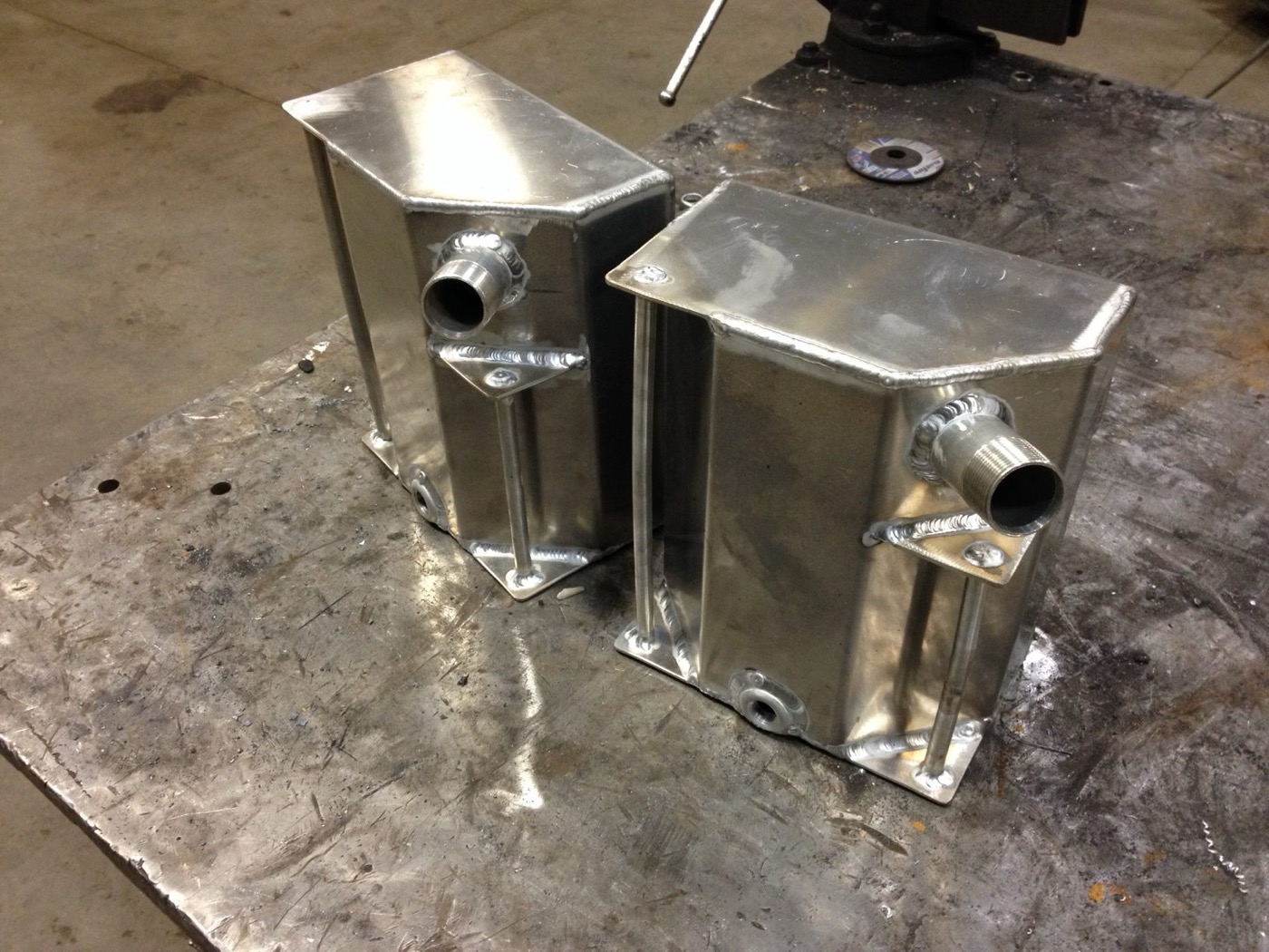 Two welded aluminum tanks with threaded fittings