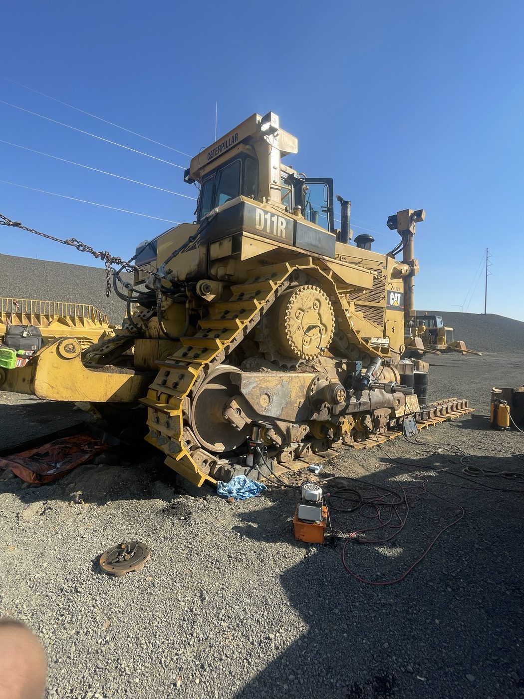 On-site work on a Caterpillar D11R dozer at a mine site with a portable hydraulic unit