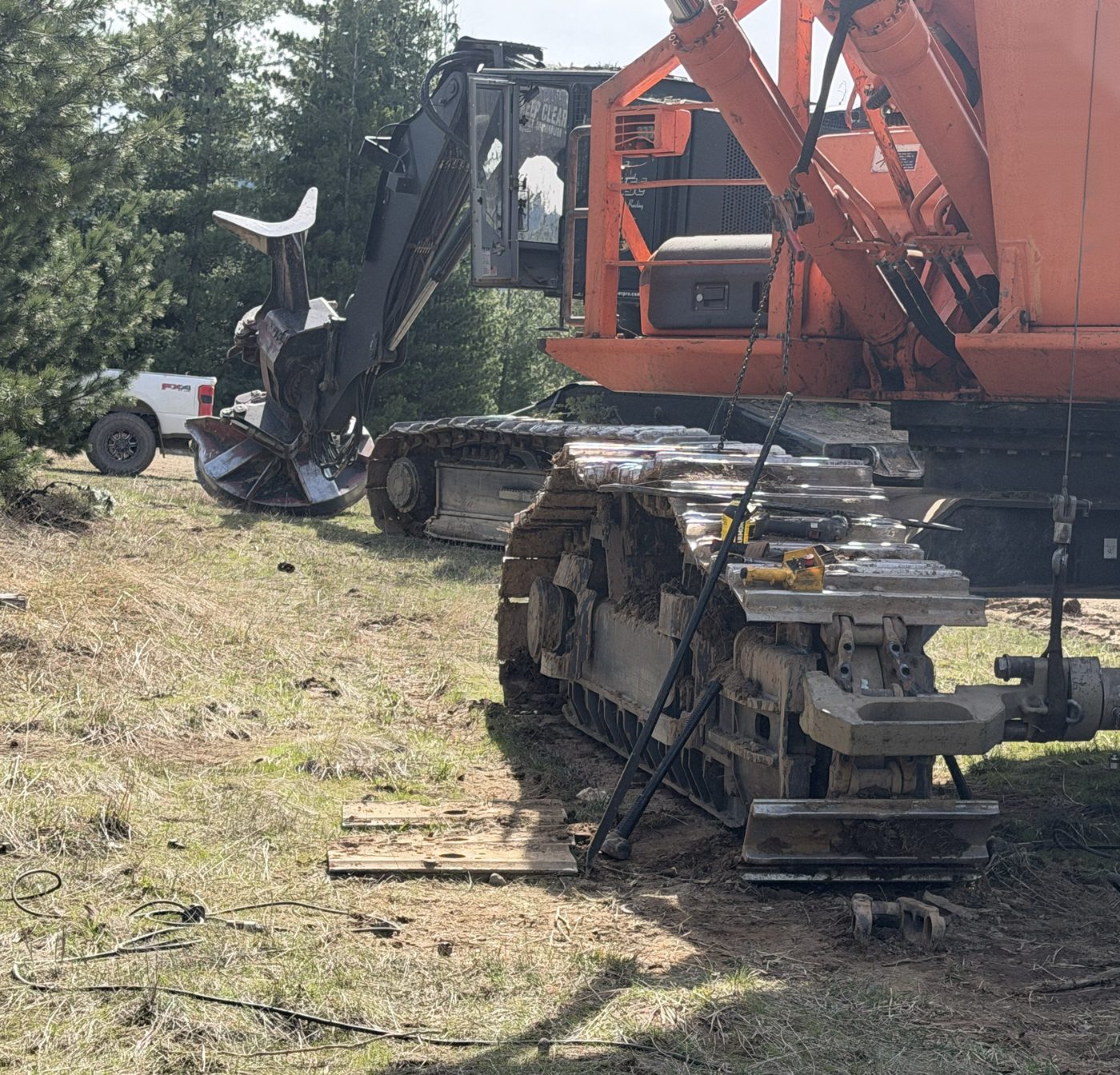 Pressing out a track pin on an orange Doosan log loader with a portable hydraulic press